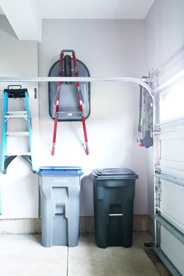 Trash and recycling bins stored neatly in a garage